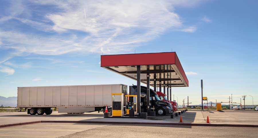 Fleet trucks refueling petrol at a station.