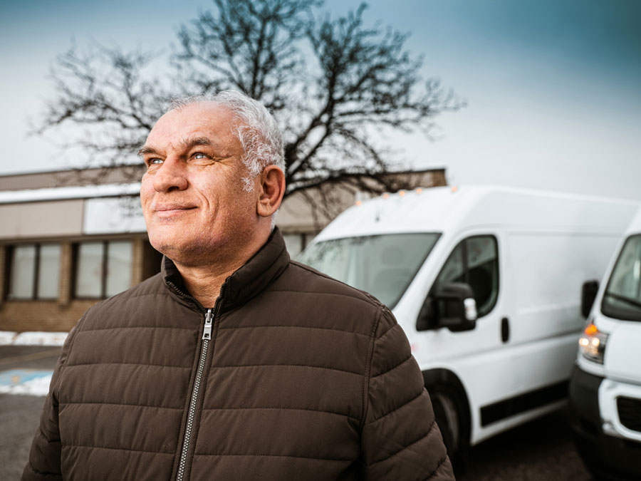 A fleet driver stands outside his rig.