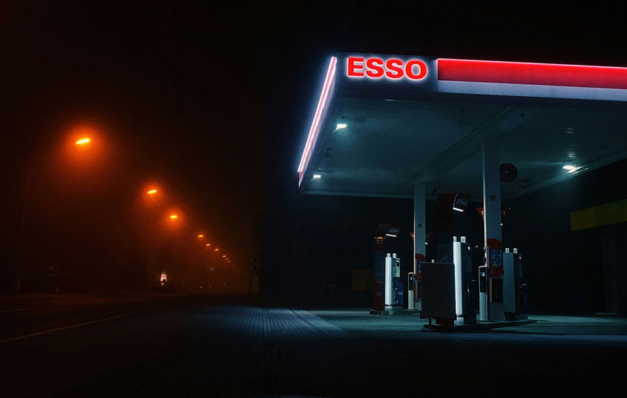 An Esso gas station lit up at night.